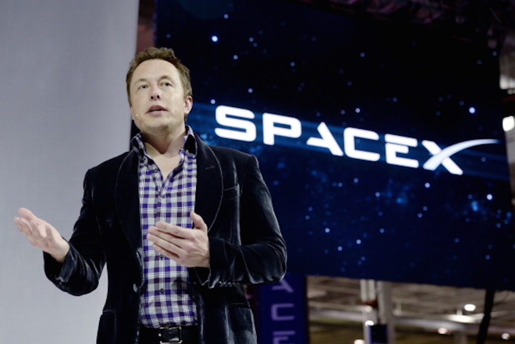 Elon Musk next to SpaceX logo