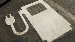 An electric vehicle symbol in a parking lot. An electric vehicle symbol in a parking lot.