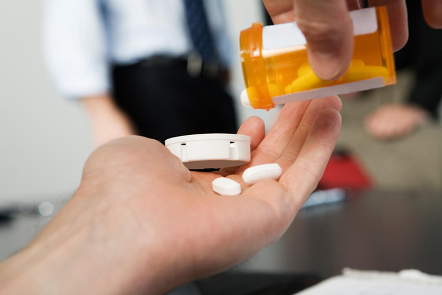 Office worker holding pills