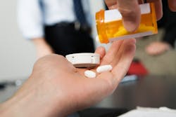 Office worker holding pills Office worker holding pills