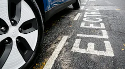 An electric Kia parked on the street.