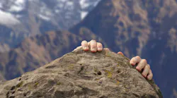man struggles to reach mountain top