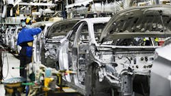 A plant employee works on a car on the assembly line. A plant employee works on a car on the assembly line.