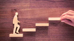 Wood cutout of executive climbing steps