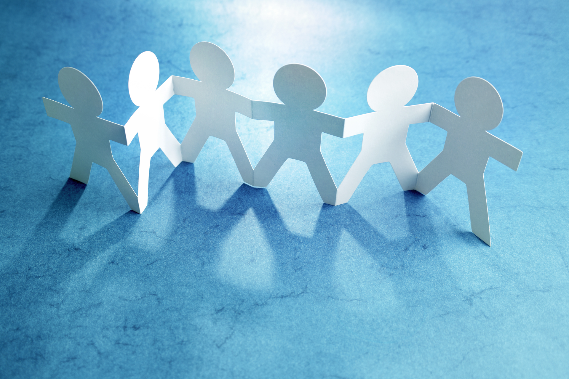 Six white paper dolls on a blue background