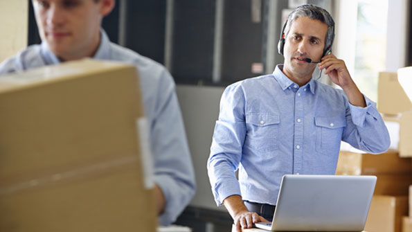 man at computer with telephone