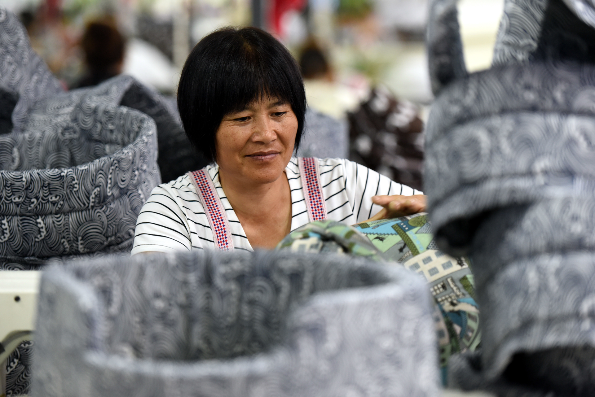 Chinese woman at factory processes fabric doghouses