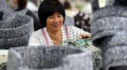 A Chinese worker processes fabric doghouses at a factory of Tancheng County in Linyi, Shandong Province of China.