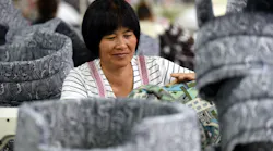 Chinese woman at factory processes fabric doghouses