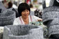 Chinese woman at factory processes fabric doghouses Chinese woman at factory processes fabric doghouses