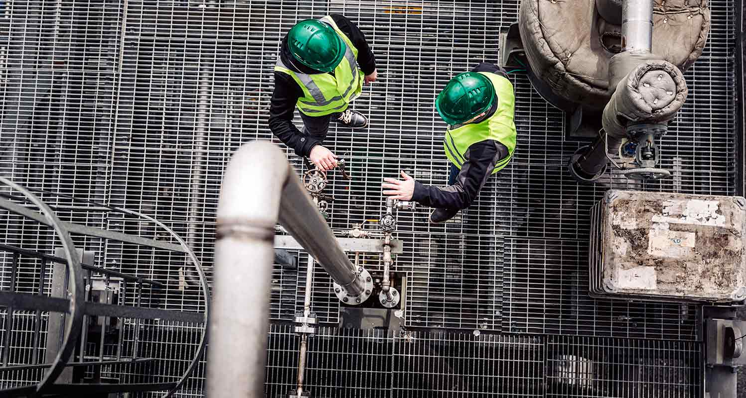 a factory view from above, 2 workers in hard hats