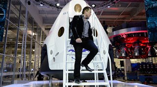 Elon Musk, head honcho of both Tesla Motors and SpaceX, descends from a SpaceX Dragon V2 spacecraft.