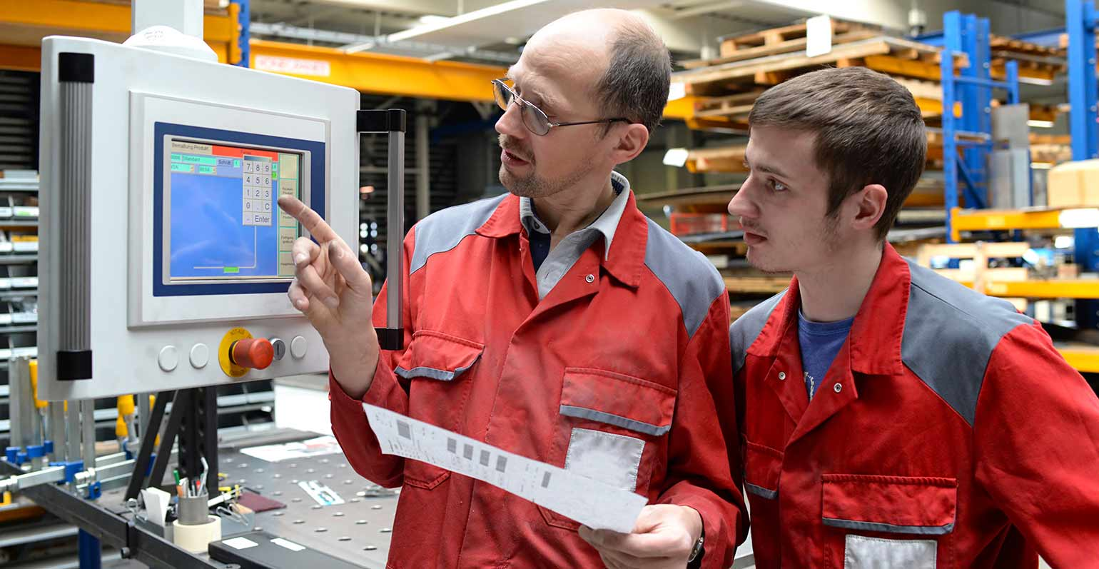 manufacturer showing young person a screen - apprenticeship