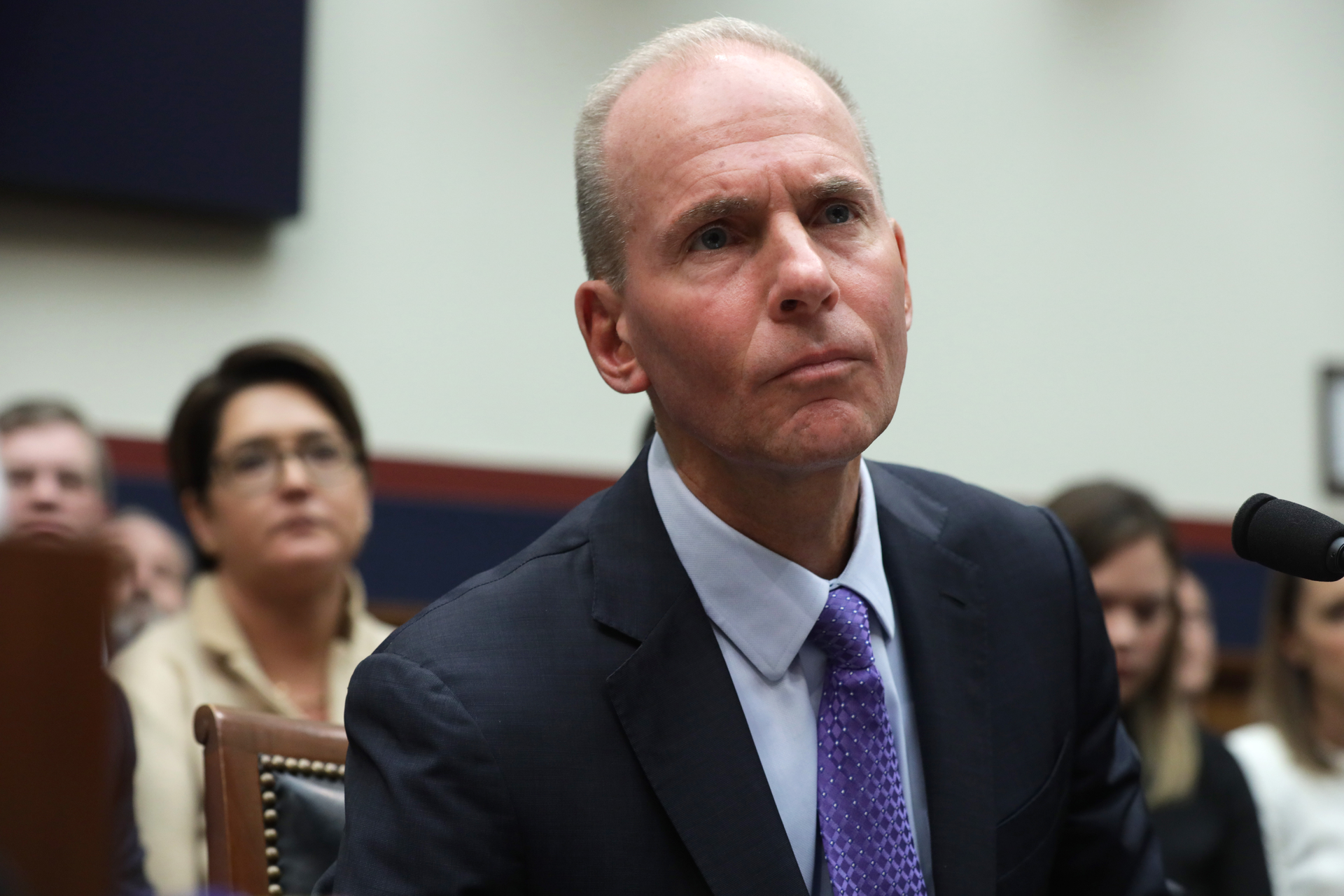 Dennis Muilenburg testifying on Capitol Hill amid a roomful of plane crash survivors in October 2019.
