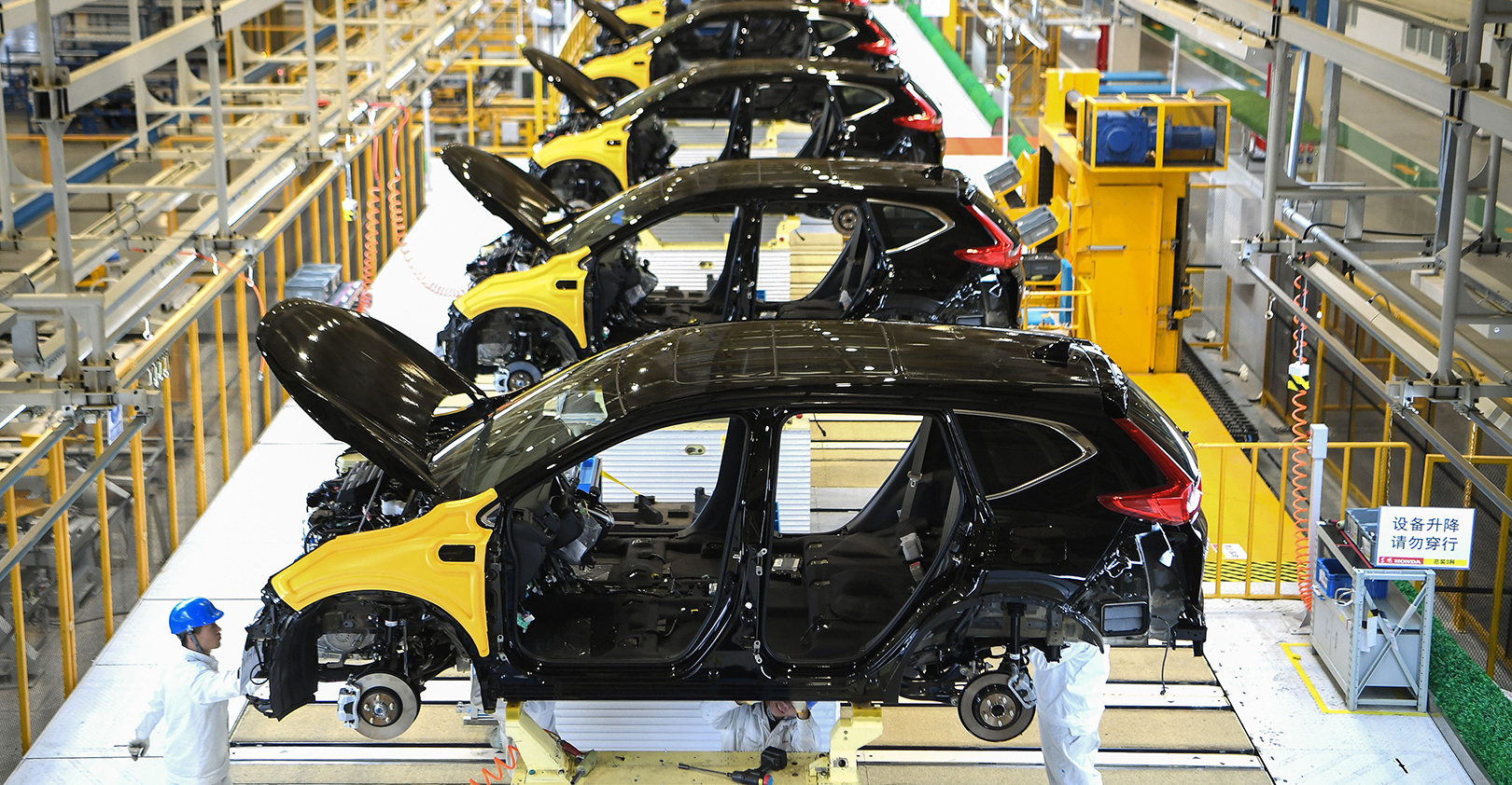 This photo taken on November 27, 2019 shows employees working on an assembly line at the third auto plant of Dongfeng Honda in Wuhan in China's central Hubei province.