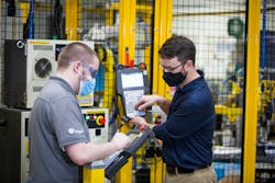 Two employees on the Industry 4.0 Development program – Jordan Klotz ( left) and Collie Crawford ( right) discuss shortcuts for “pick and place” routines on the robots teach pendant for the new automated dishwasher spray arm assembly cell. Two employees on the Industry 4.0 Development program – Jordan Klotz ( left) and Collie Crawford ( right) discuss shortcuts for “pick and place” routines on the robots teach pendant for the new automated dishwasher spray arm assembly cell.