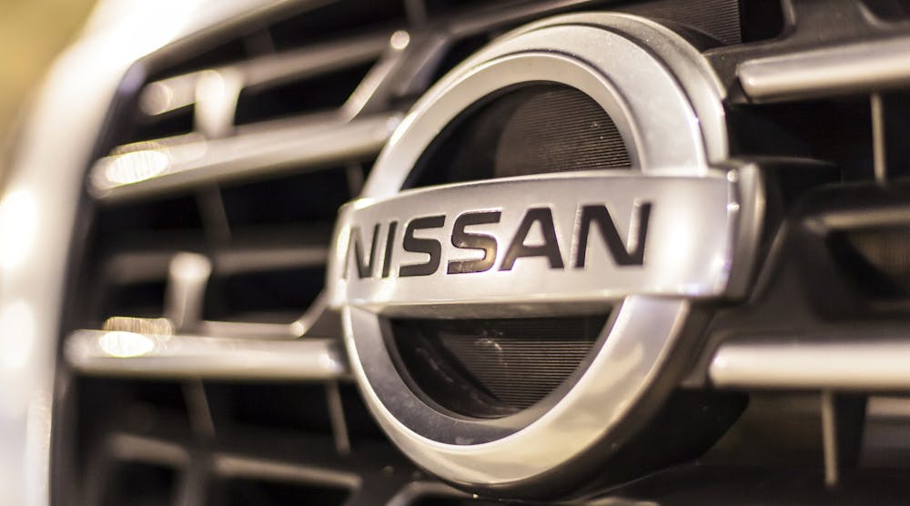 A closeup of the company&apos;s logo on the grille of a Nissan vehicle.