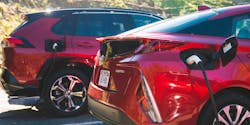 A photo of two red Toyota plug-in hybrid vehicles. A photo of two red Toyota plug-in hybrid vehicles.