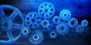 A system of gears against a blue background. An abstract representation of manufacturing and industry.