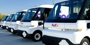 A lineup of BrightDrop EV600 electric delivery vans in FedEx livery.