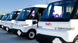A lineup of BrightDrop EV600 electric delivery vans in FedEx livery.