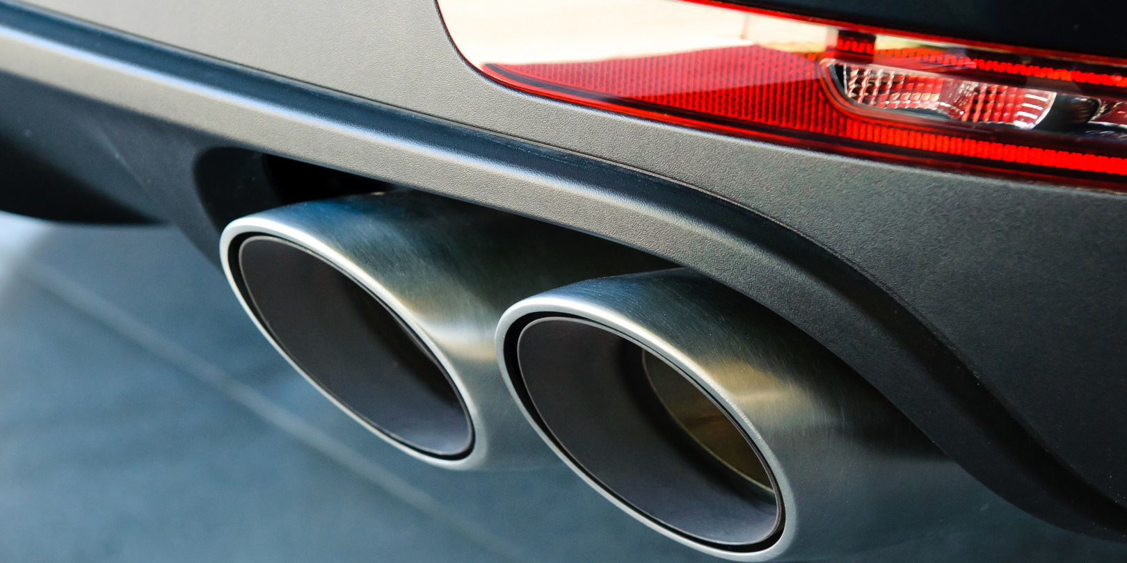 A closeup of a car's dual exhaust pipes.