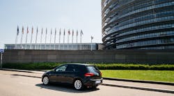 A Volkswagen Golf drives outside the European Parliament building.