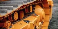 A closeup on the treads of heavy construction equipment painted bright yellow. A closeup on the treads of heavy construction equipment painted bright yellow.