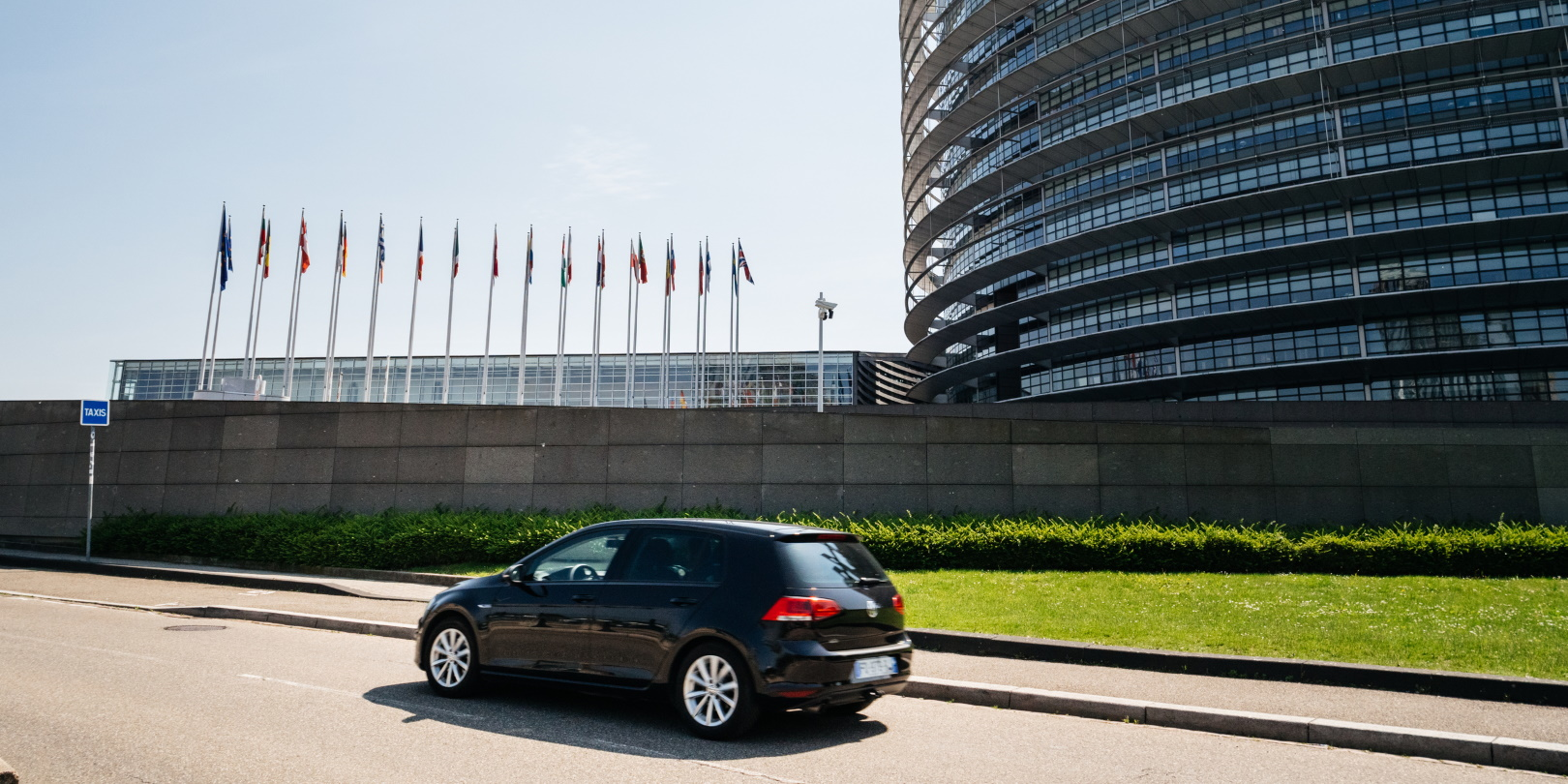 A Volkswagen Golf drives outside the European Parliament building.