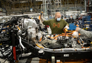 An autoworker at Stellantis' Toledo, Ohio, Jeep plant works on an electric version of the Wrangler. The UAW and automakers will no longer require workers to wear facemasks to protect against COVID-19.