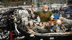 An autoworker at Stellantis&apos; Toledo, Ohio, Jeep plant works on an electric version of the Wrangler. The UAW and automakers will no longer require workers to wear facemasks to protect against COVID-19.