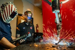 Joel Sander, left, and Brian Stempka, right, working at McDowell Manufacturing’s robotic welder. Joel Sander, left, and Brian Stempka, right, working at McDowell Manufacturing’s robotic welder.