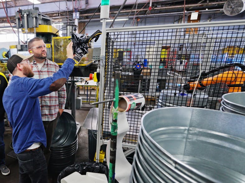 Bill Bellingham, vice president of manufacturing at Behrens (right) inspects cobot operations on the plant floor.