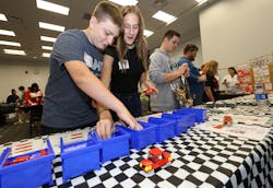 Students from Triad Local Schools work together on assembling a model car.