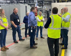 Yelton, at far right, talks with Eaton workers on a plant visit.