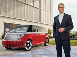 Kjell Gruner stands to the right of a Volkswagen vehicle. Kjell Gruner stands to the right of a Volkswagen vehicle.