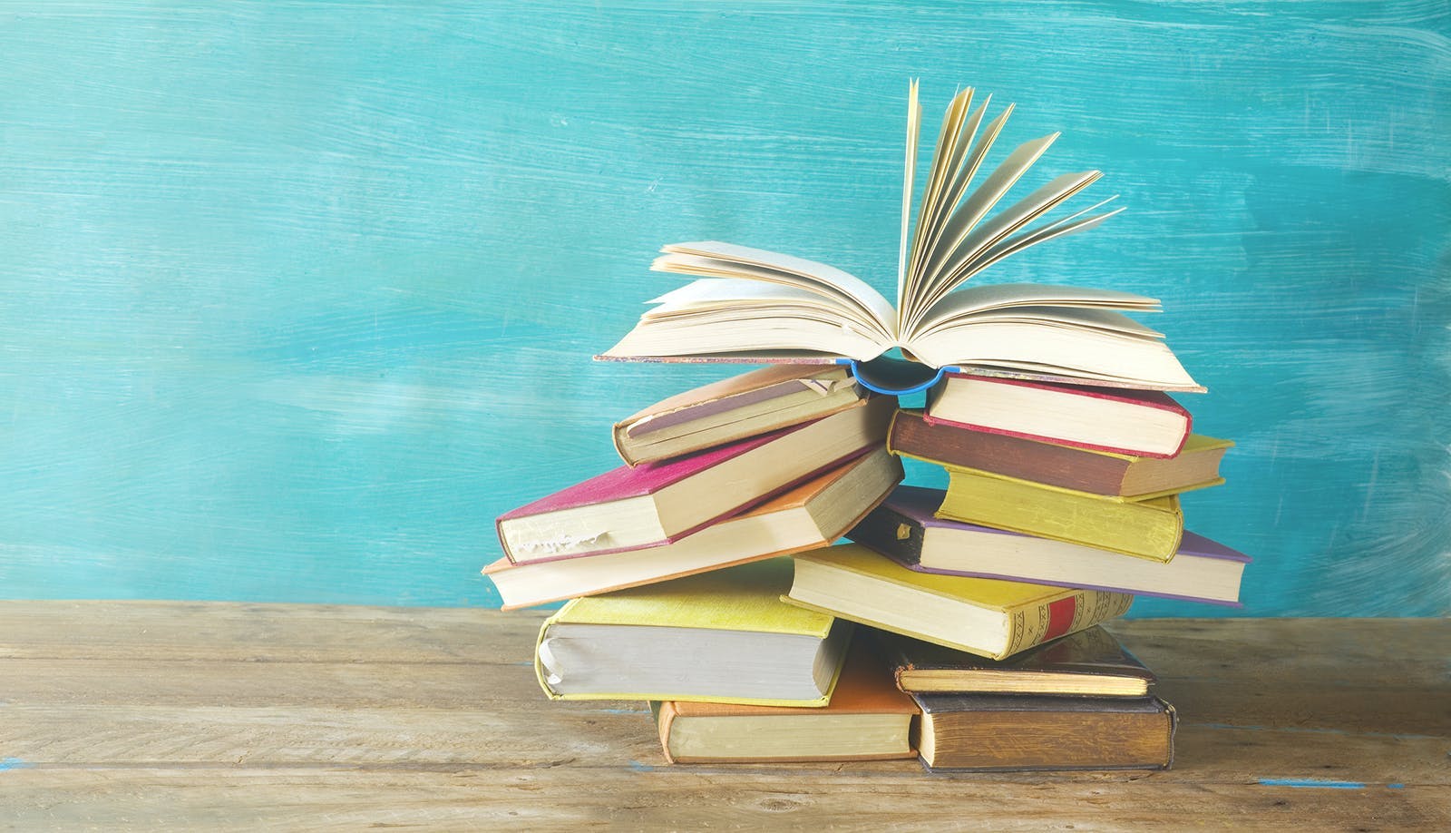 Stack of books against light blue background.
