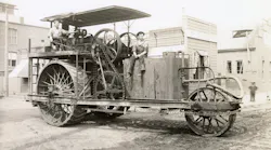 sepia toned photo of two people on a Holt tractor, before it became Caterpillar.