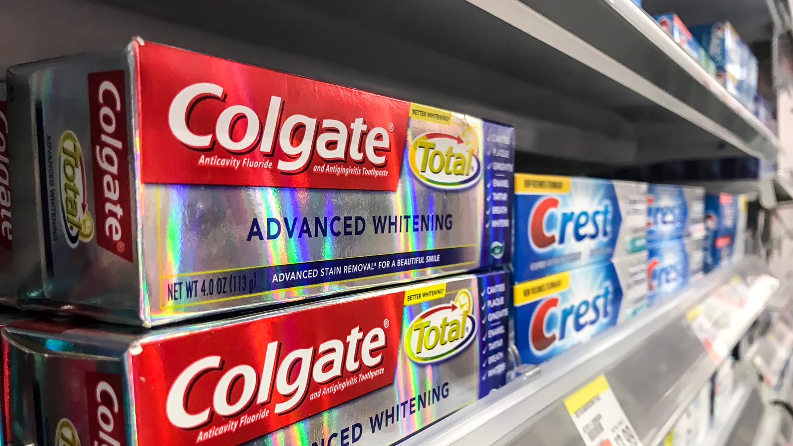 Colgate and Crest toothpaste on store shelf