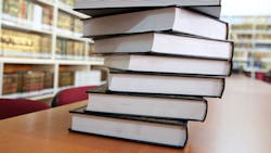stack of books on library table stack of books on library table