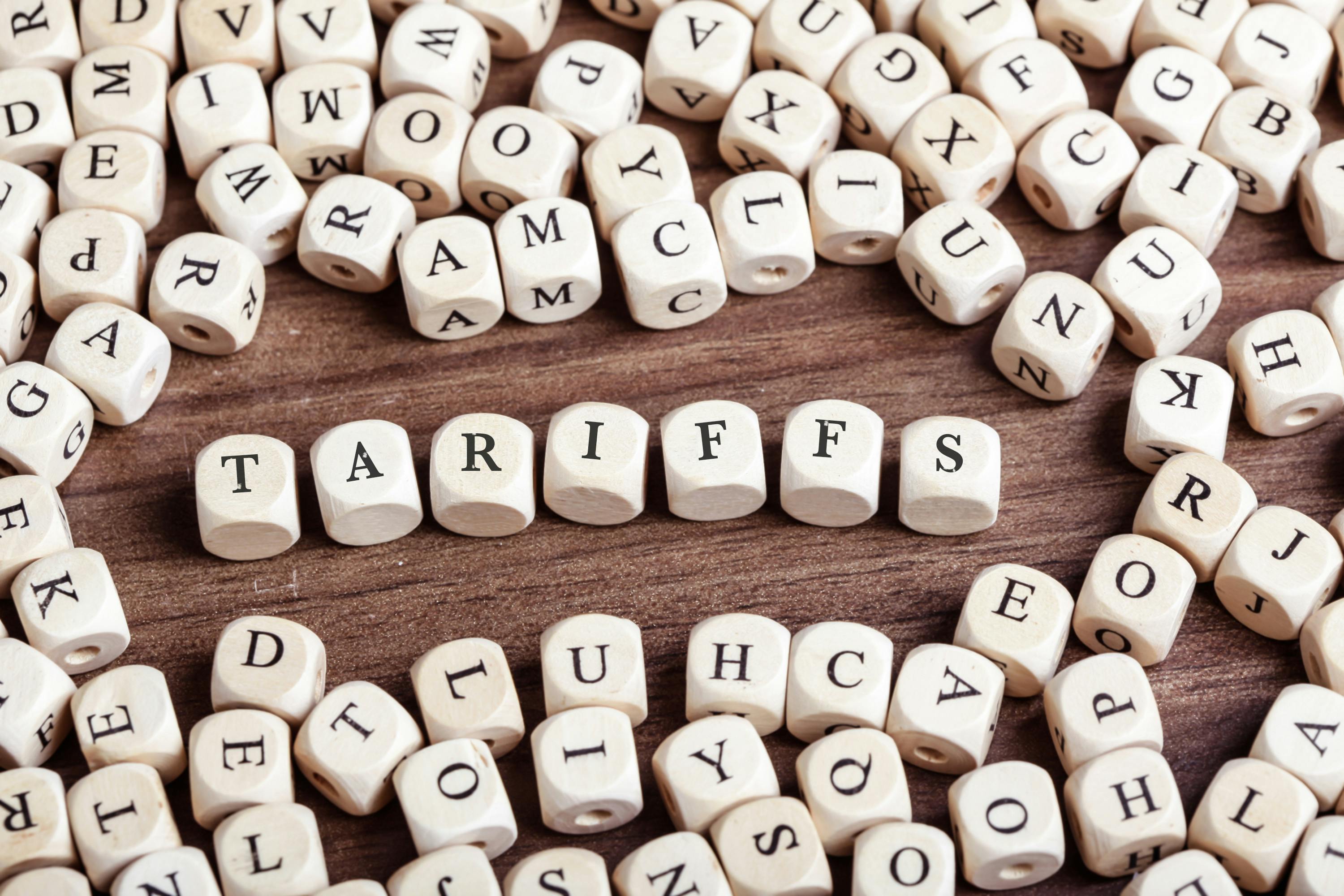 Word tariffs in letters on cube dice on table.