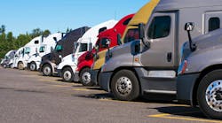 Big rigs semi trucks of different makes and models stand in row. Big rigs semi trucks of different makes and models stand in row.
