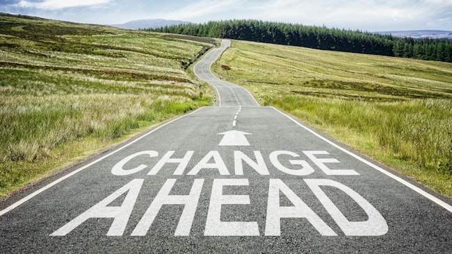 Image of a long road with an arrow and the words 'Change Ahead.'