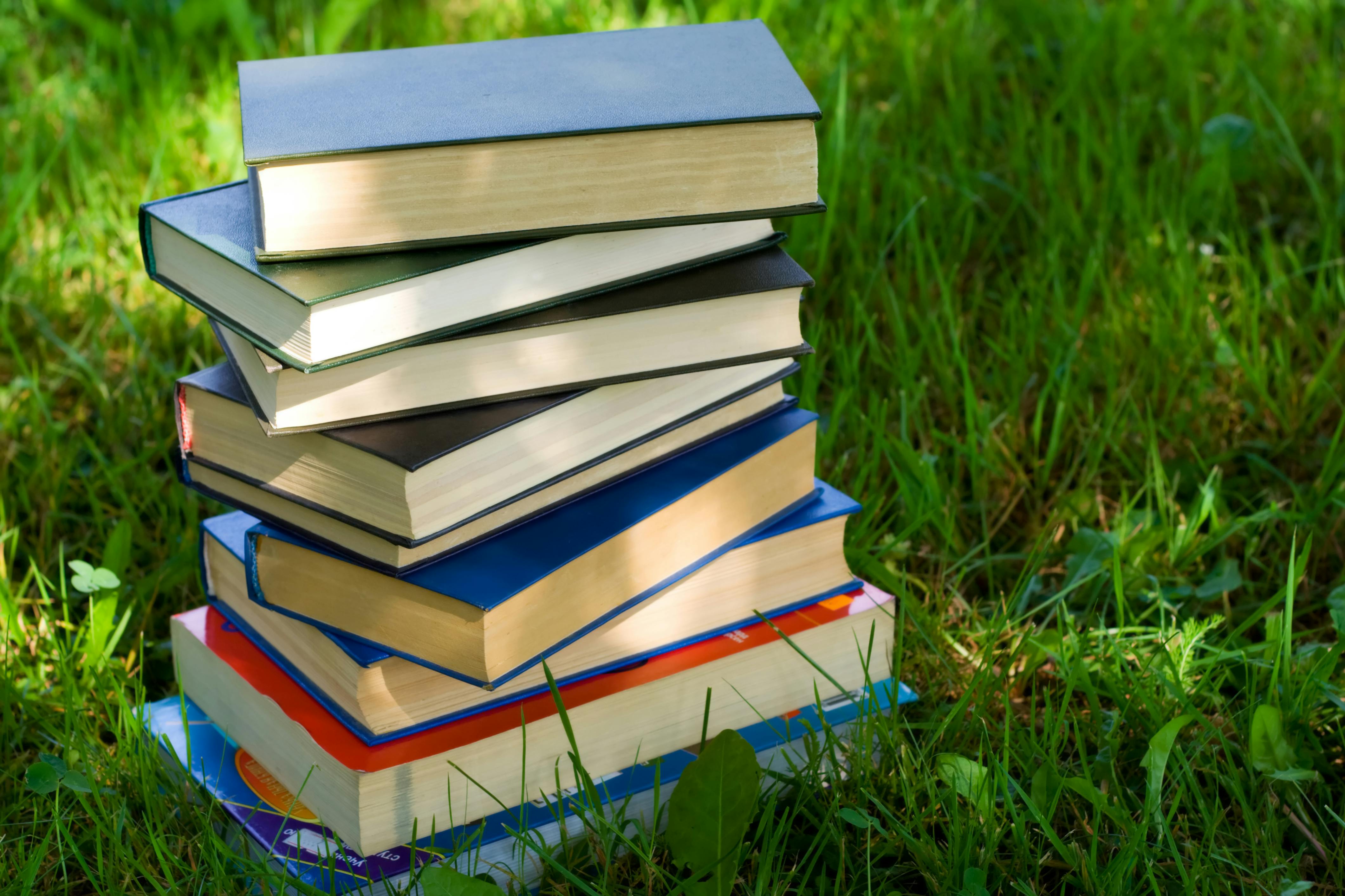 Stack of books on green grass