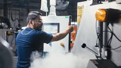 A FNOK Santa Ana employee operates a cryogenic deflashing machine. A FNOK Santa Ana employee operates a cryogenic deflashing machine.