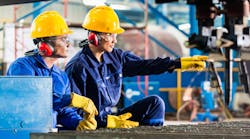 Workers in factory at industrial metal cutting machine. Workers in factory at industrial metal cutting machine.