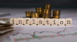 Word INFLATION composed of wooden letters. Stacks of coins in the background Word INFLATION composed of wooden letters. Stacks of coins in the background