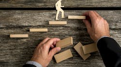 Silhouette cutouts of a man walking up steps. The hand of a businessman is building the stairs for him. Silhouette cutouts of a man walking up steps. The hand of a businessman is building the stairs for him.