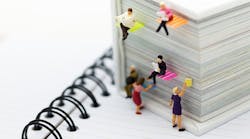 Miniature people reading newspapers on a big book Miniature people reading newspapers on a big book