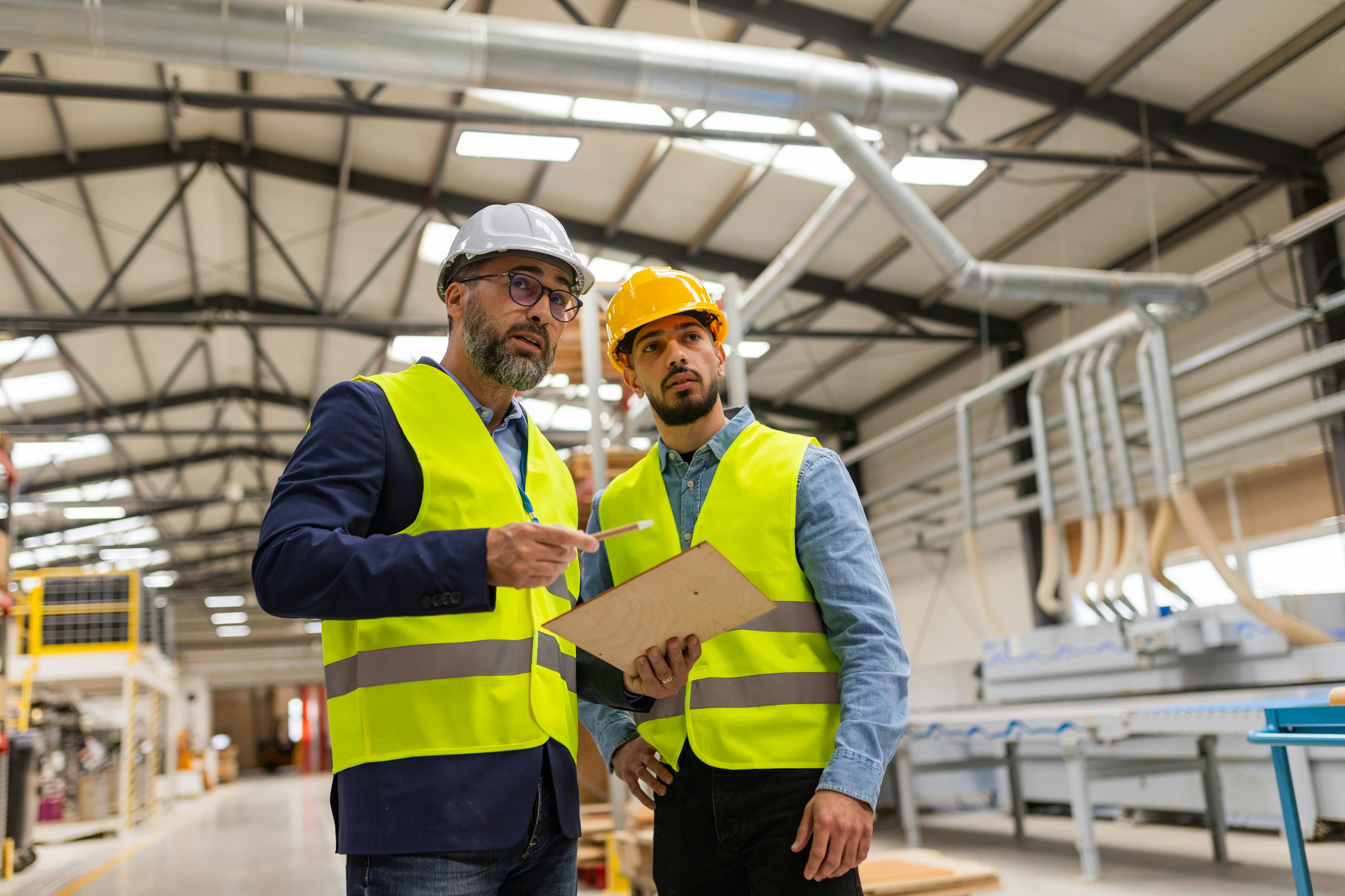 Engineer consulting with foreman in modern industrial factory